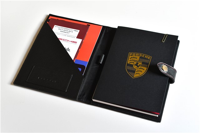 "60Y 911" Dokumentenmappe, im Pepitamuster, mit geprägtem Porsche Wappen, 60 Jahre 911 Jubiläum Plakette